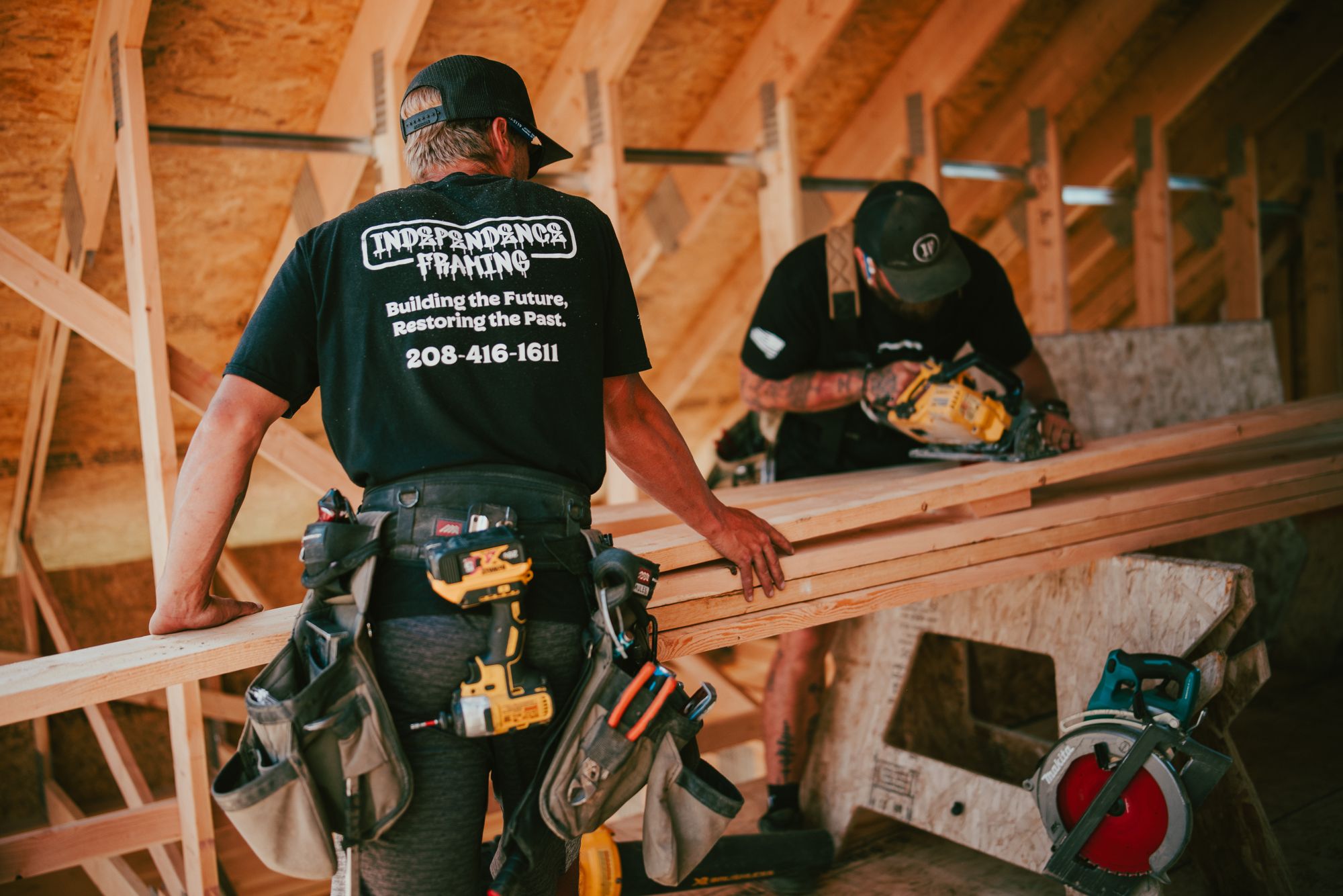 Two IB carpenters measuring and cutting lumber
