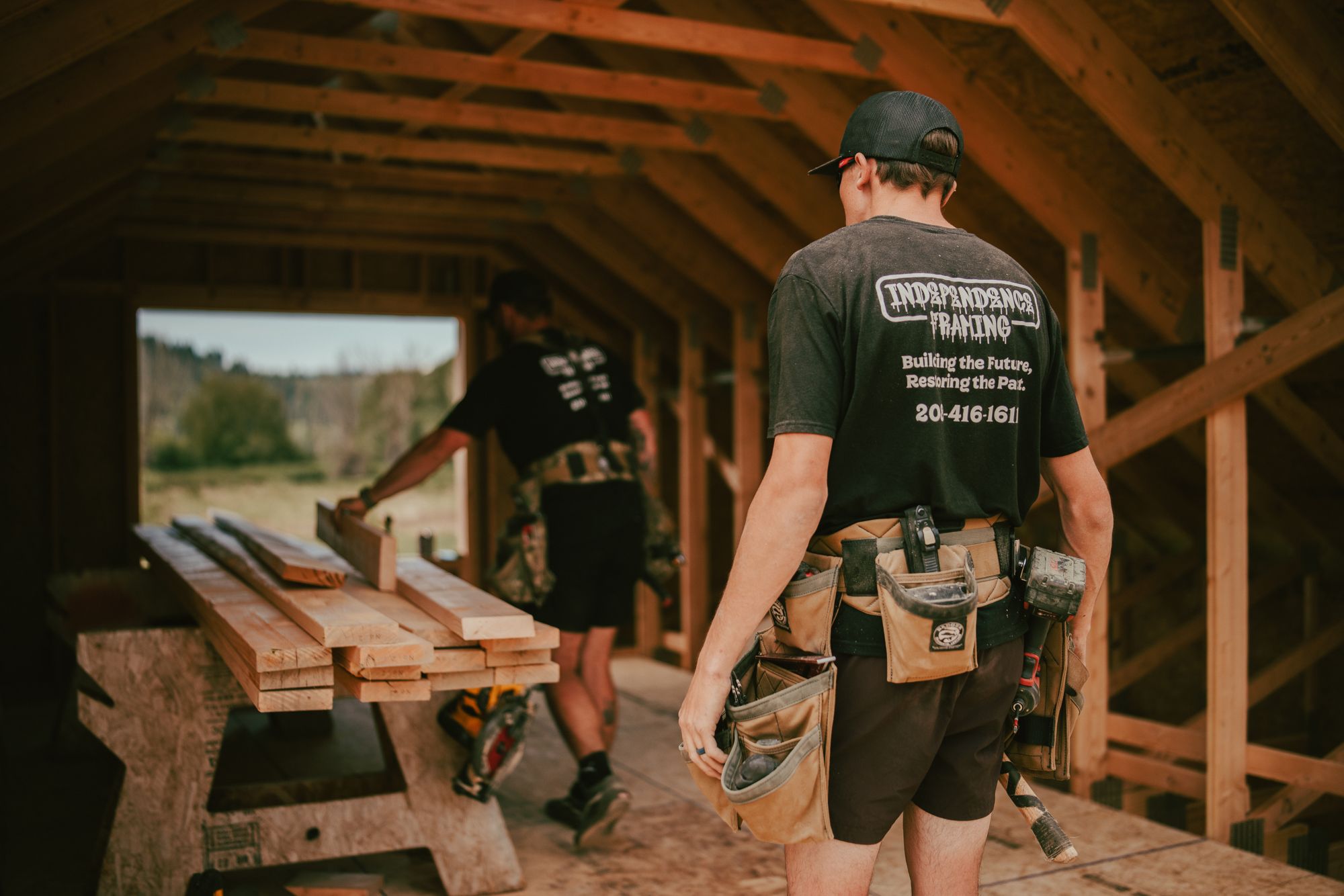 Two IB carpenters working inside the framed structure