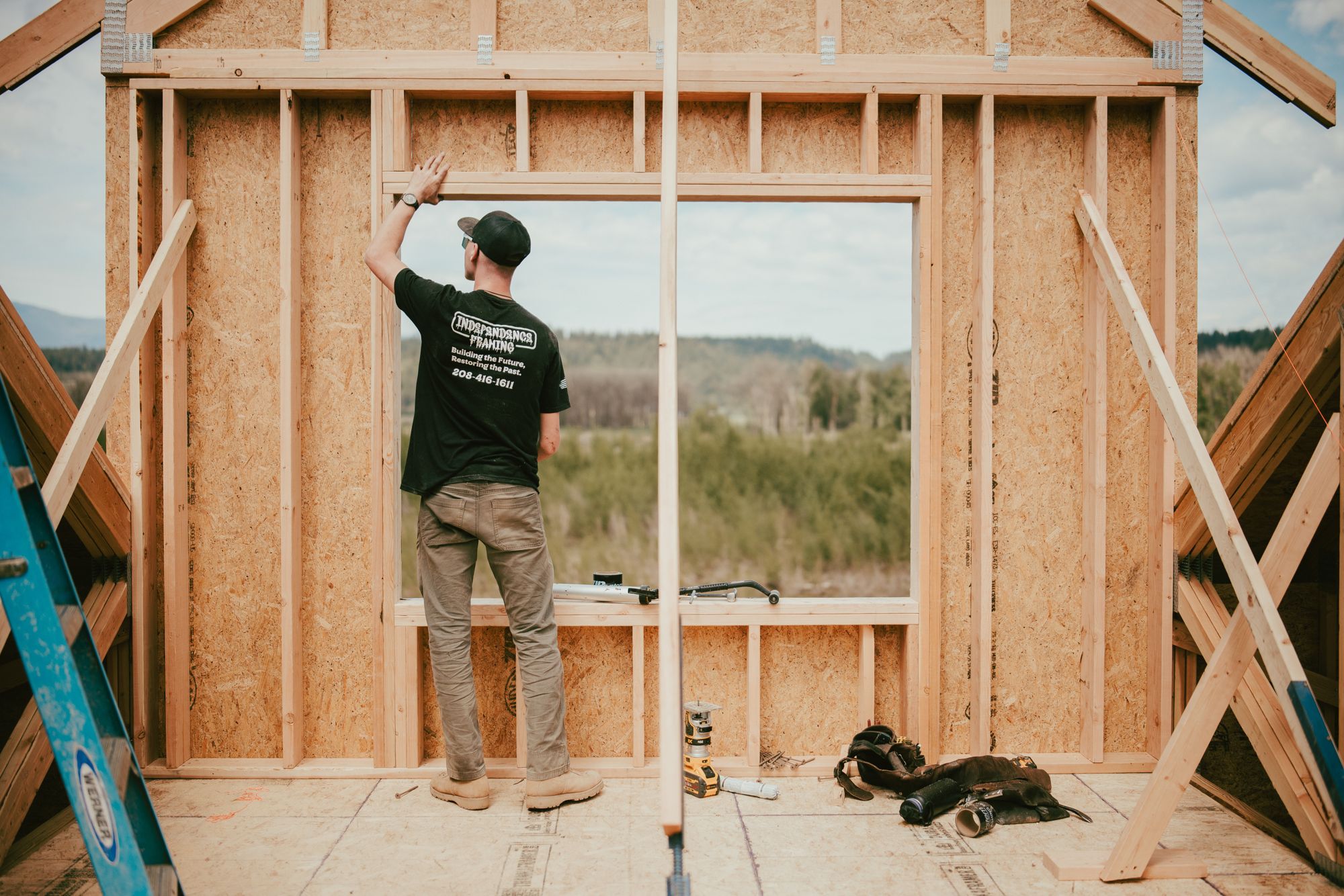 James Benson framing a wall opening that looks out over a North Idaho valley